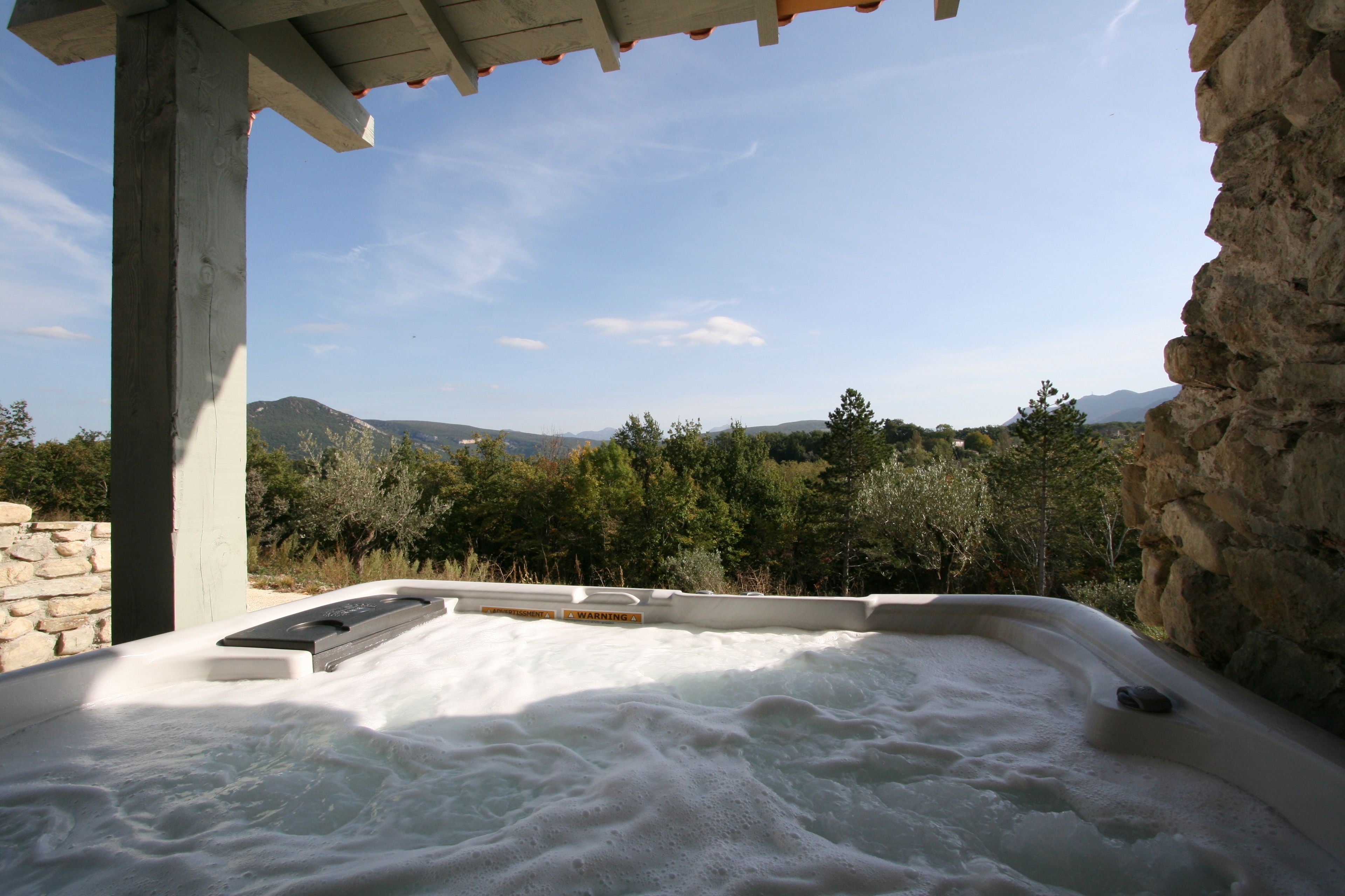 A hot tub with a view of mountains and trees.