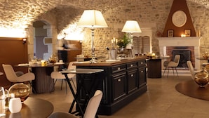 A cozy interior with a stone ceiling, a fireplace, and a bar area with seating.