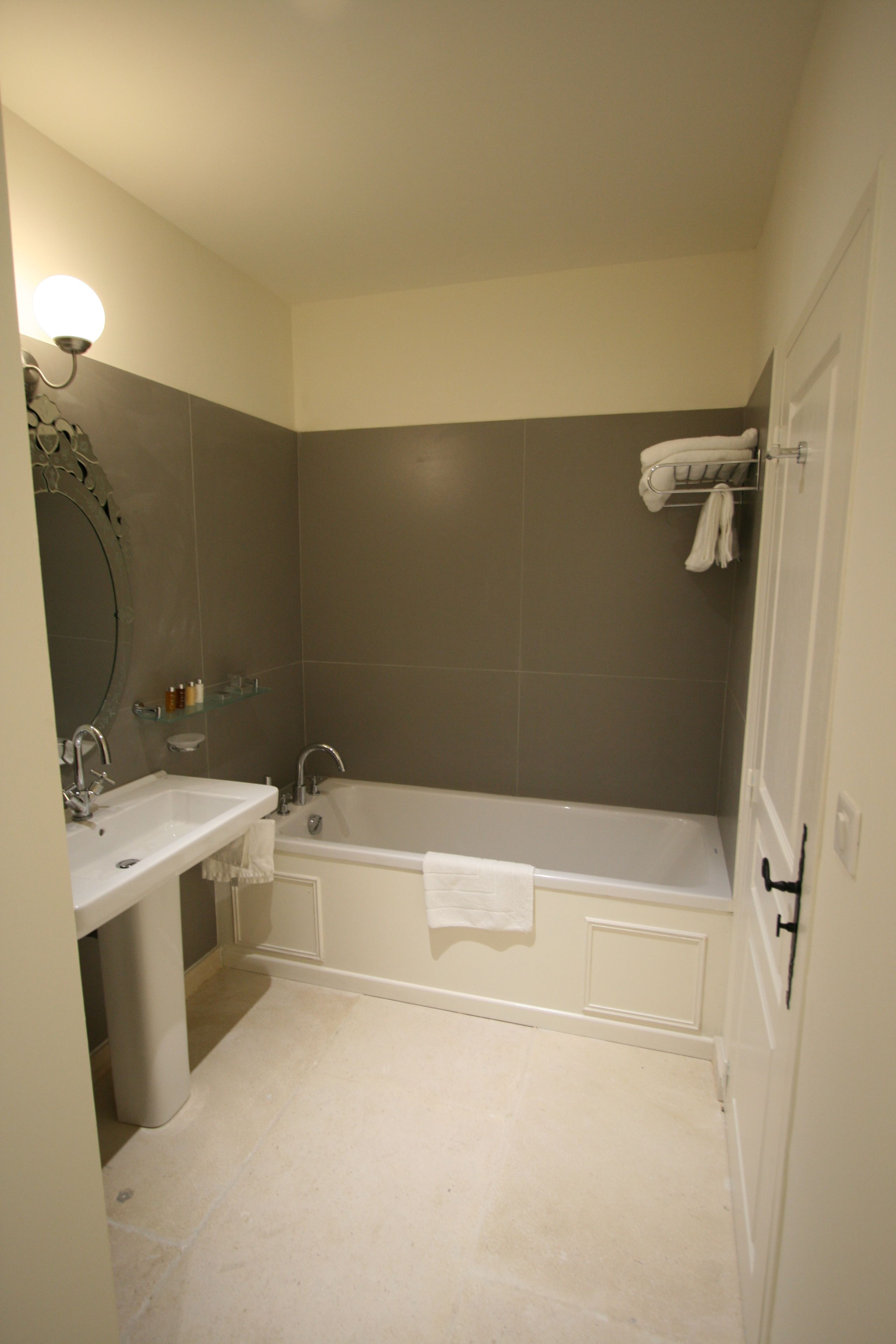 A bathroom with a sink, mirror, and bathtub.