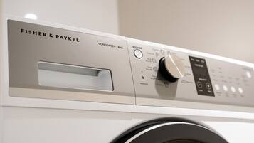 En Fisher & Paykel vaskemaskine med kontrolpanel, der viser en tænd/sluk-knap, tidsindstillinger og en låsefunktion.