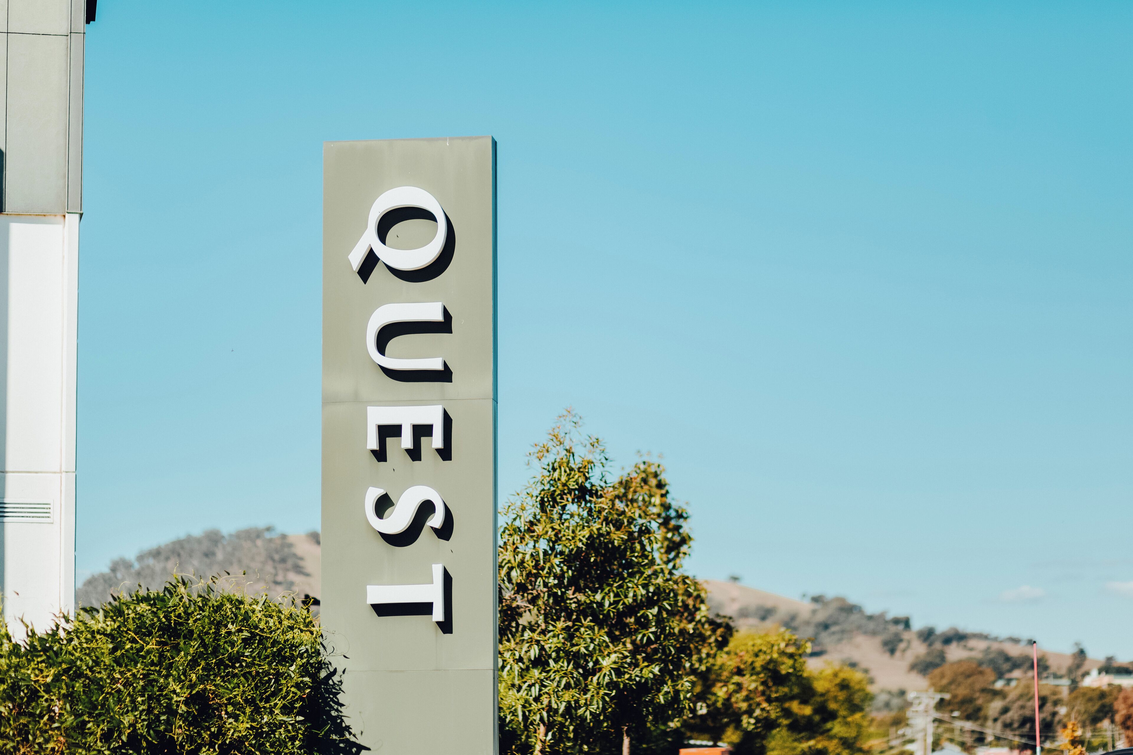 A vertical sign with the word "QUEST" on it.