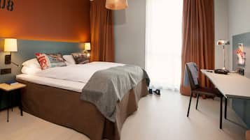 Ein modernes Hotelzimmer mit einem großen Bett, einem Schreibtisch und einem Sessel.