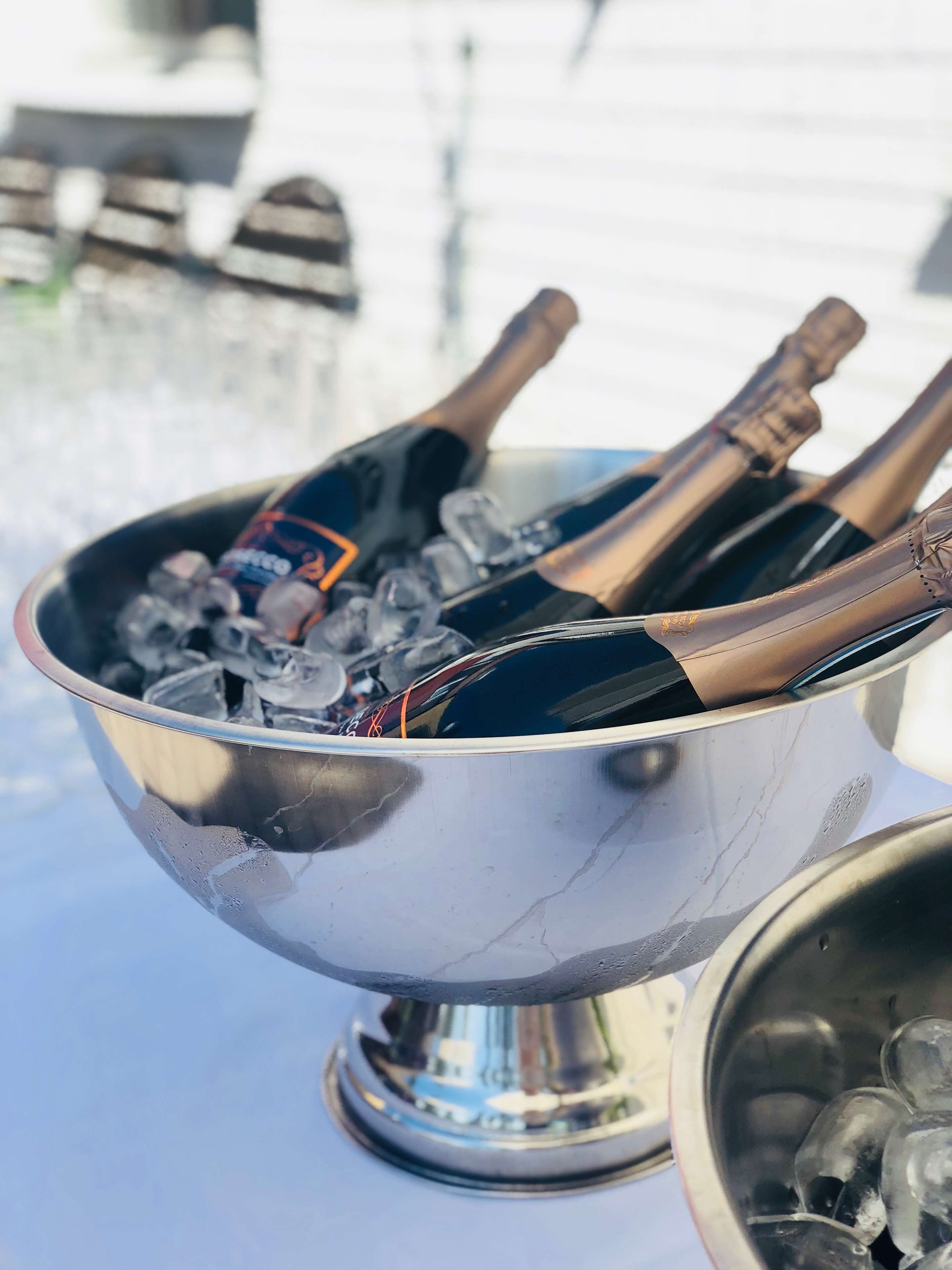 Un cuenco metálico lleno de hielo y dos botellas de champán.