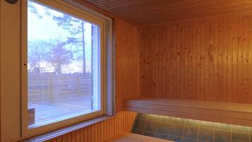 Una sauna con pareti in legno, una panchina e una finestra.