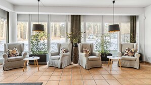 A modern living room with two armchairs, a coffee table, and a large window with a view of the outdoors. - Hotel Malmkoping, BW Signature Collection (Malmkoping)