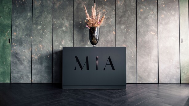 Un mostrador de recepción moderno con las letras "MIA" bien visibles.