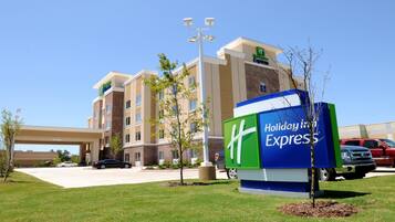 Welcome to Holiday Inn Express, featuring a modern design with a brick facade and large windows.