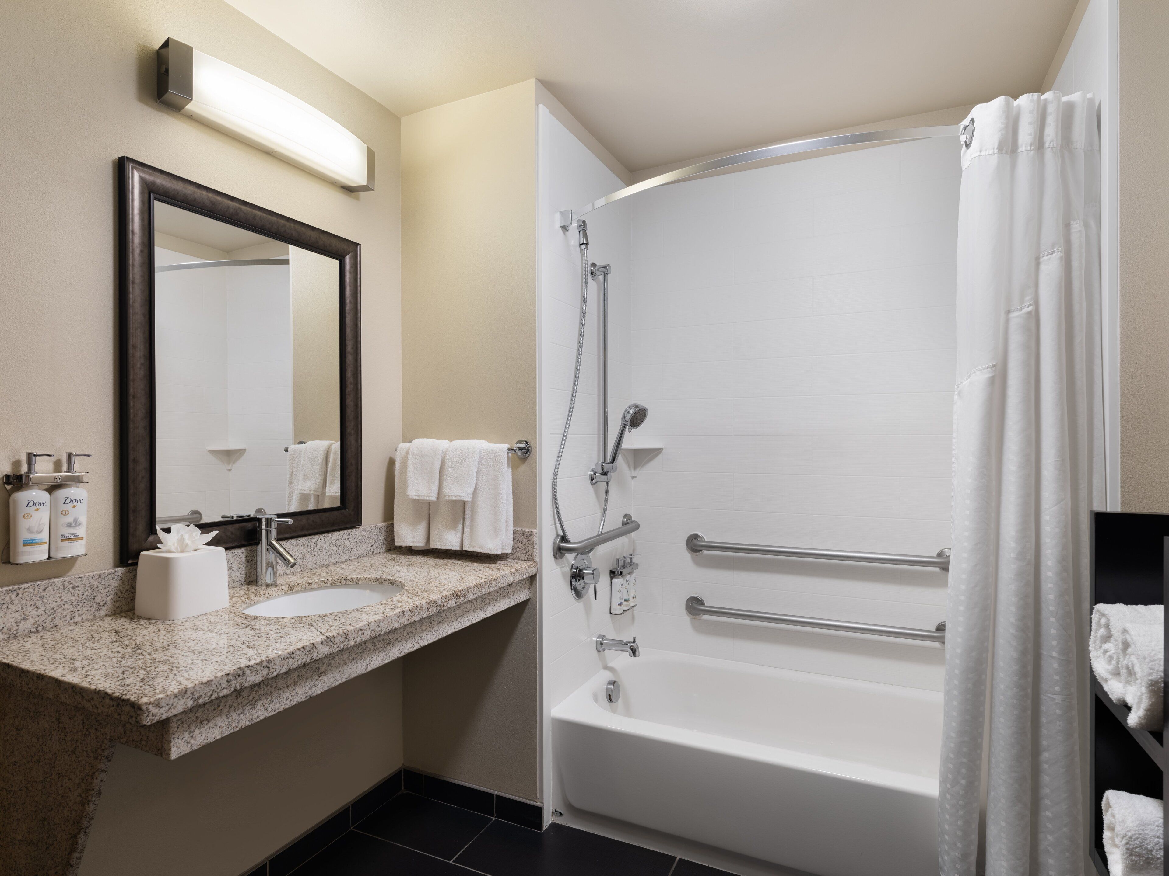 A modern bathroom with a sink, mirror, shower, and bathtub.