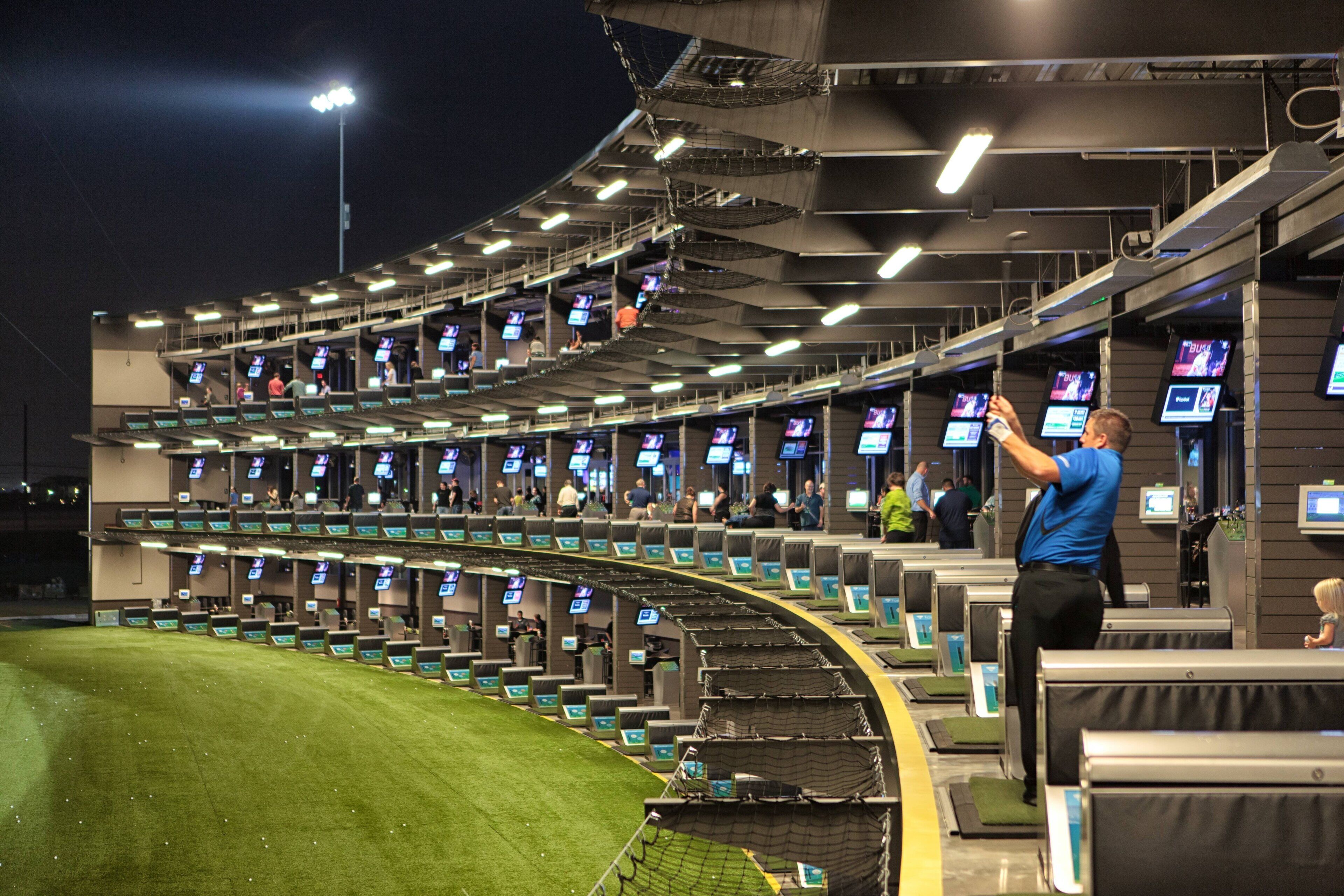 A stadium seating area with multiple rows of seats and overhead monitors.