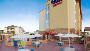 A Marriott hotel with outdoor seating and a swimming pool. - Fairfield Inn & Suites Houston-North Spring (Spring)