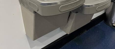 A wall-mounted sink with a faucet and a soap dispenser.