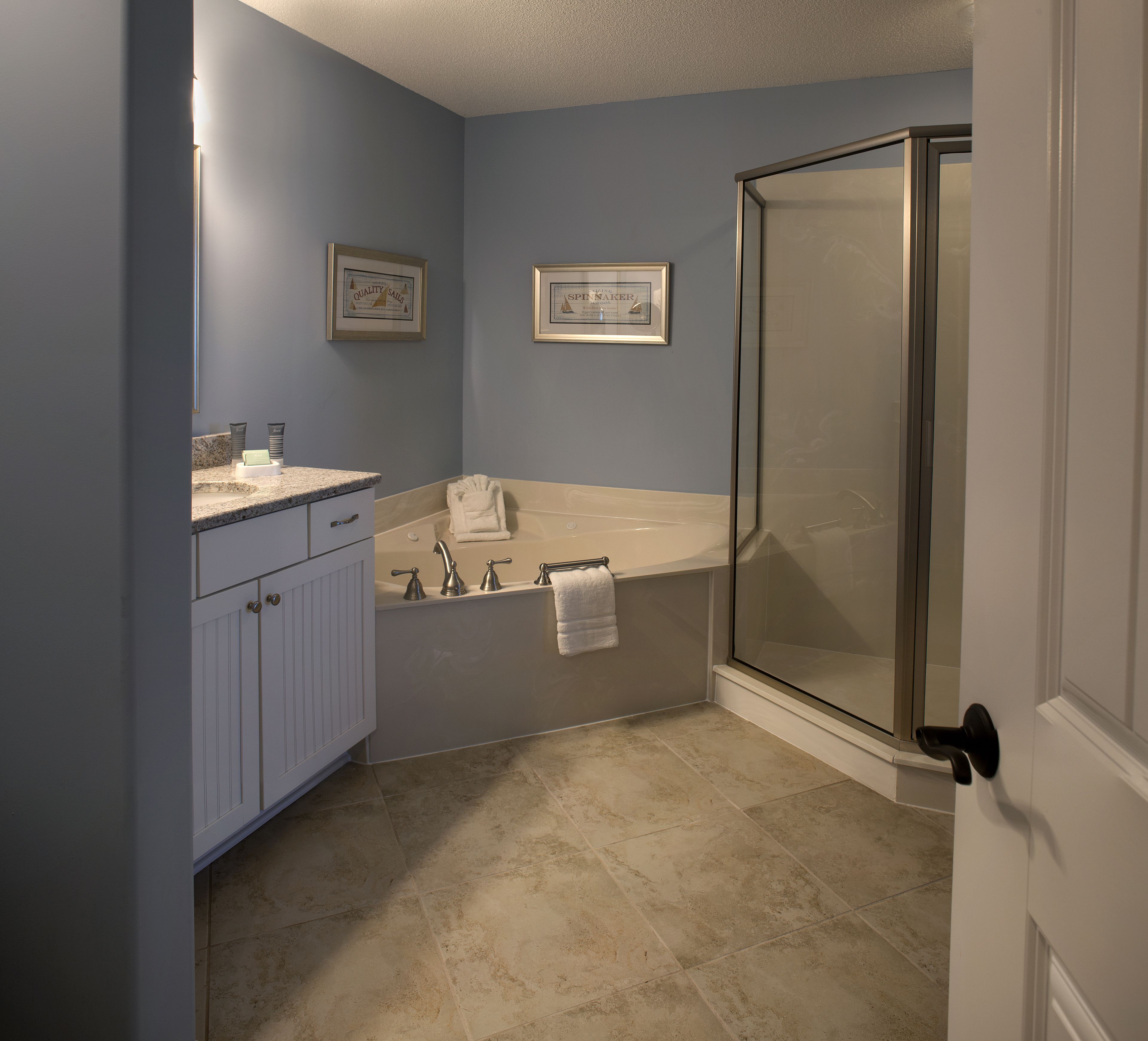 A bathroom with a bathtub, a shower, and a vanity with a sink.