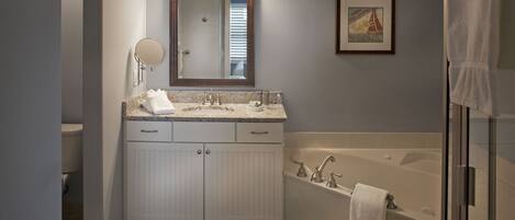A bathroom with a double sink vanity, a large mirror, a framed picture, and a walk-in shower.