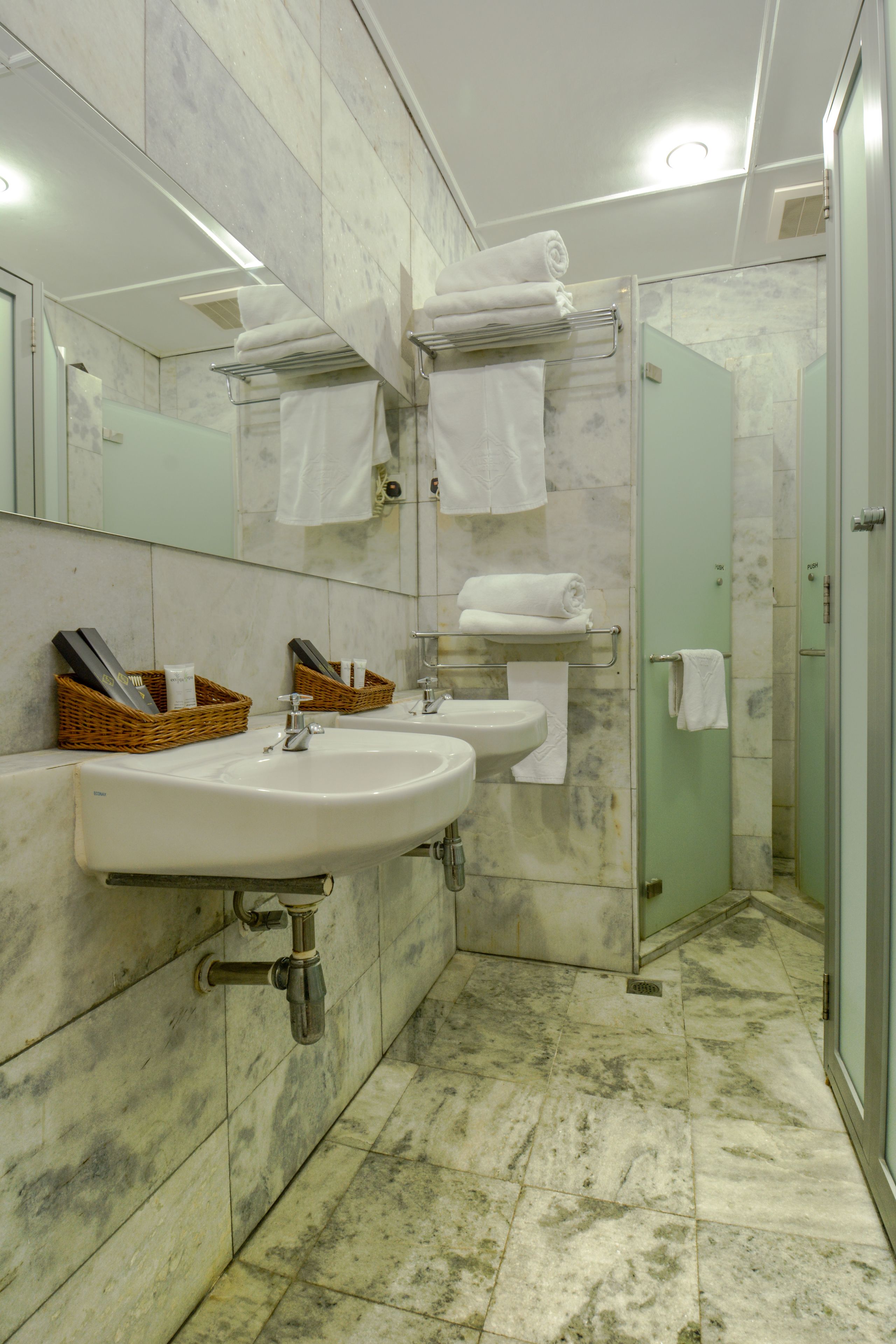 A bathroom with two sinks, a mirror, and a glass shower enclosure.