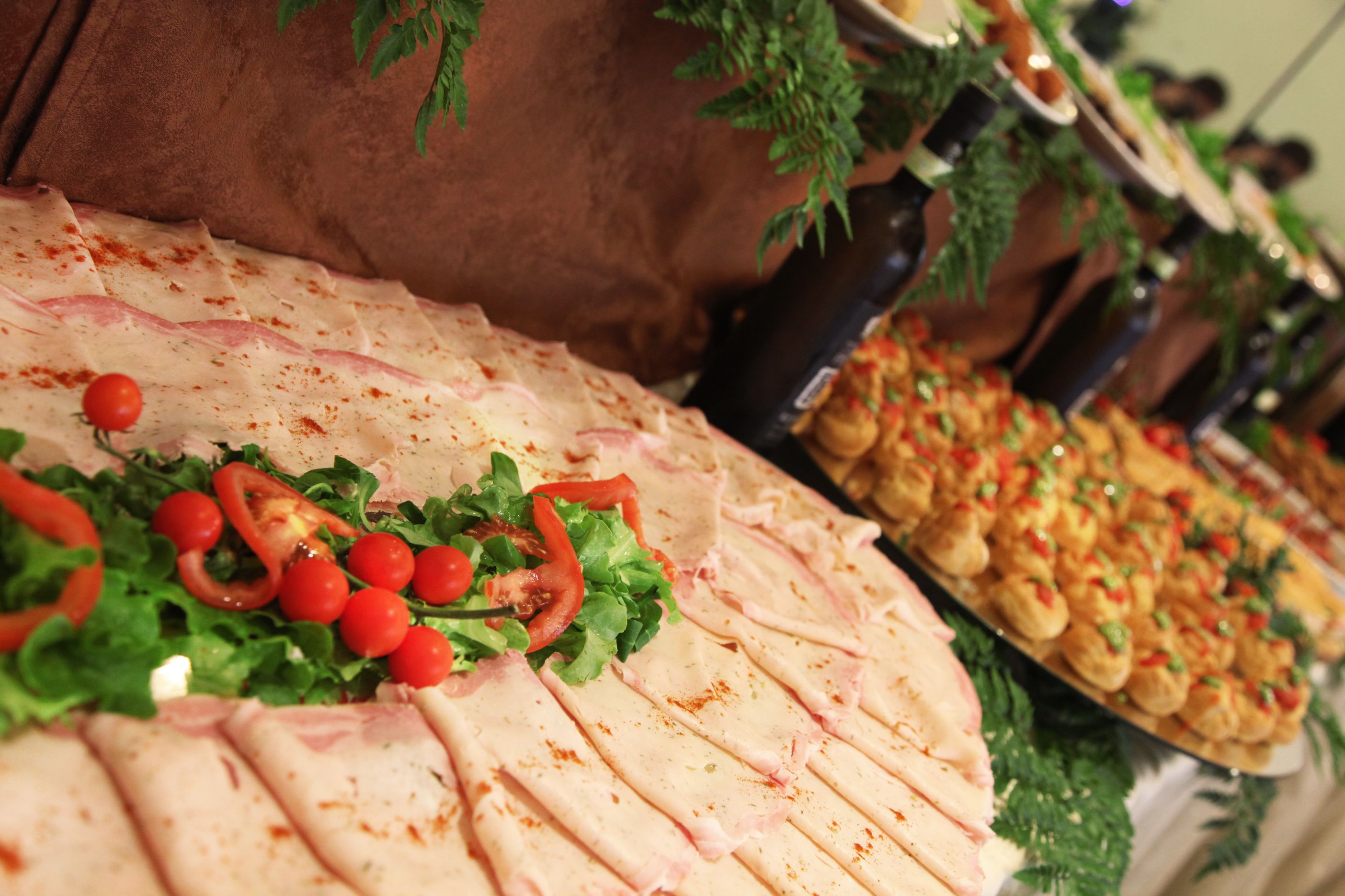 A buffet with various food items including sliced meats, salads, and appetizers.