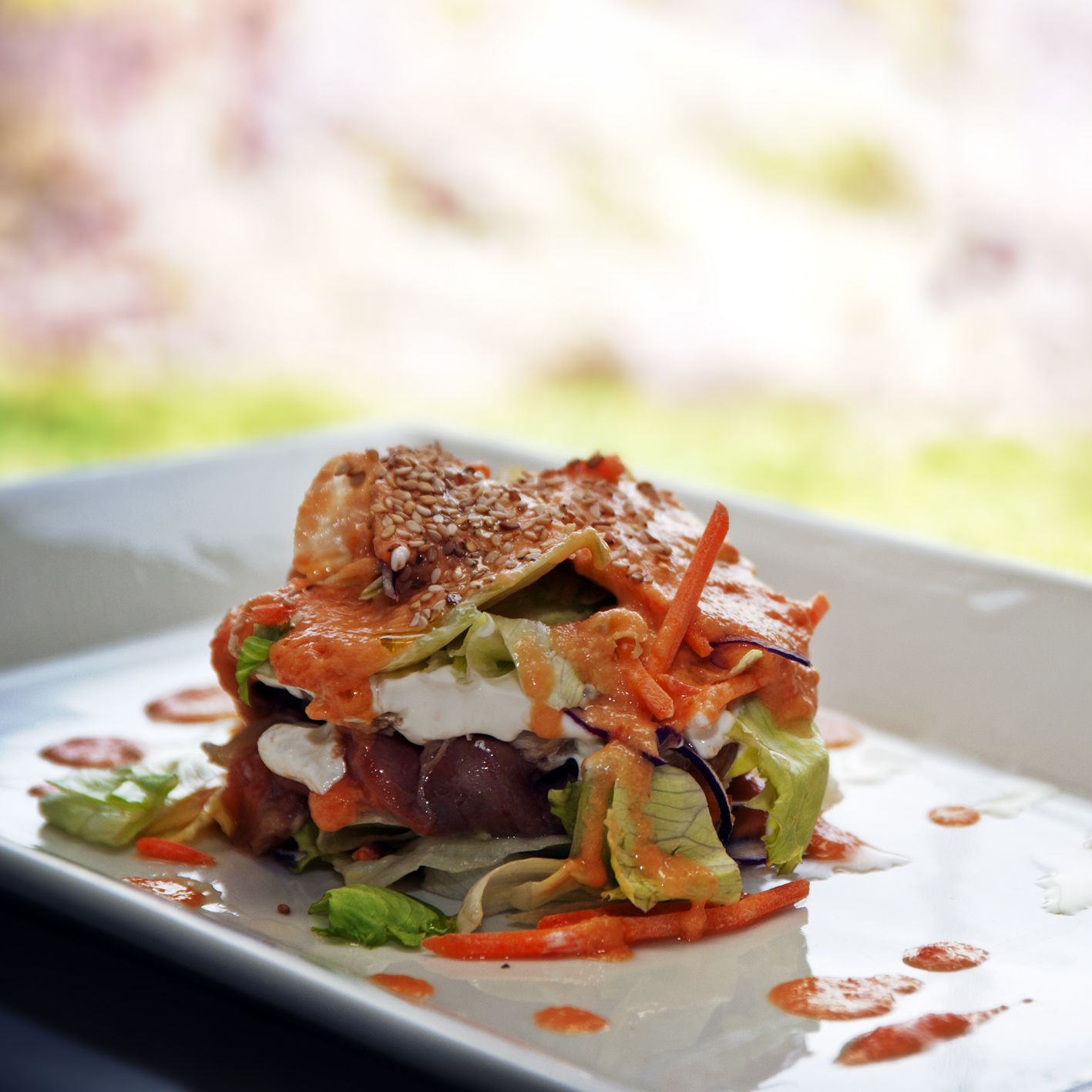 A dish with various ingredients and a sauce on a plate.