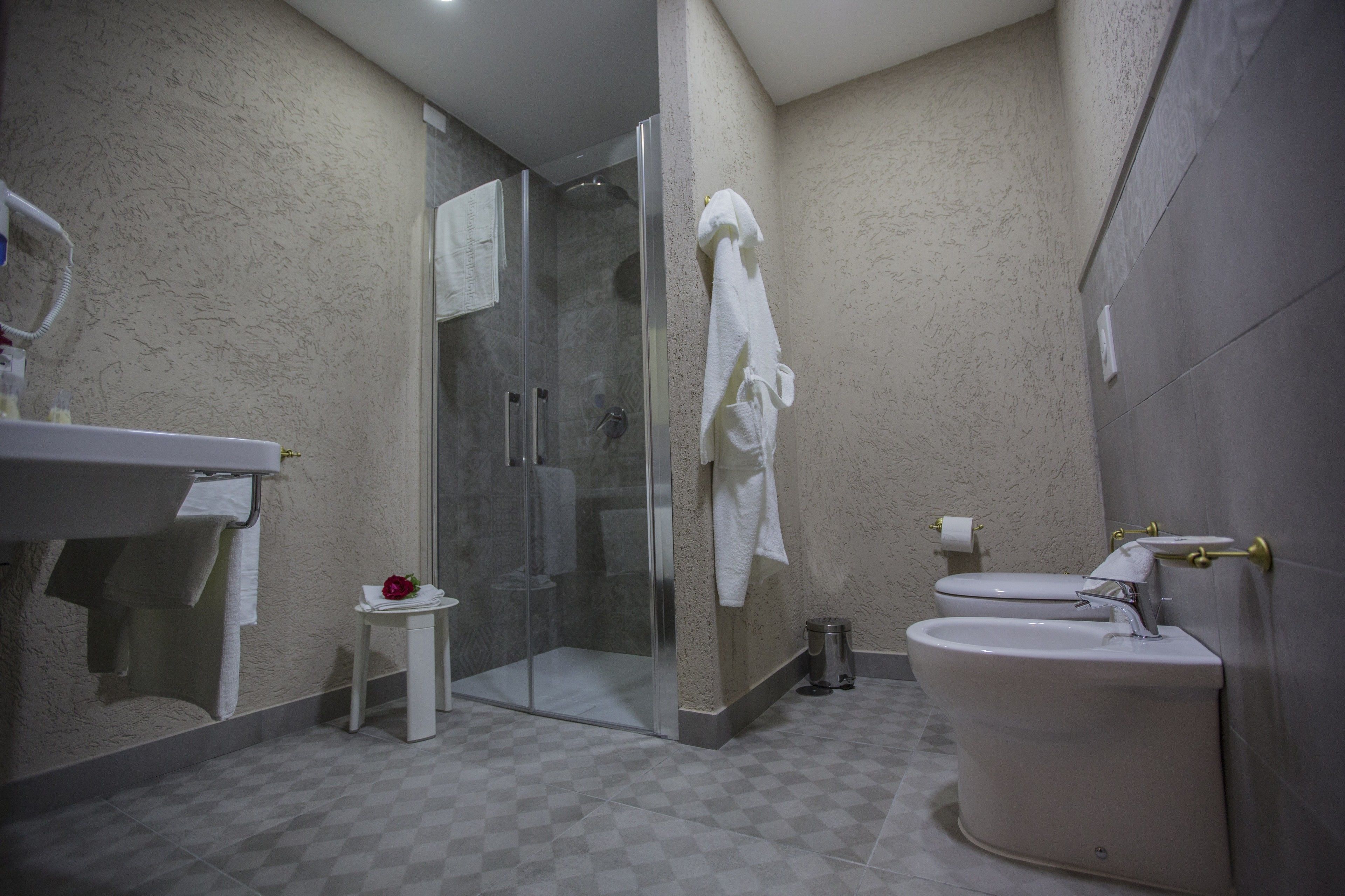 Un bagno con doccia vetrata, un water e un lavandino.