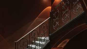 Un magnifique escalier avec des rampes en métal ouvragé et un éclairage chaleureux.