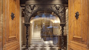 A grand entrance with a checkered floor, ornate wooden doors, and a staircase leading to an upper level. - Arai Aparthotel (Barcelona)