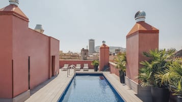 Una piscina al aire libre, sillones reclinables de piscina