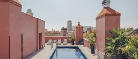 Una piscina al aire libre de temporada, tumbonas