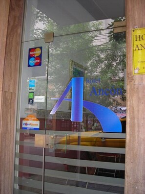 Una puerta de cristal con una gran flecha azul, el logotipo de Mastercard y un letrero de EmerPhone.