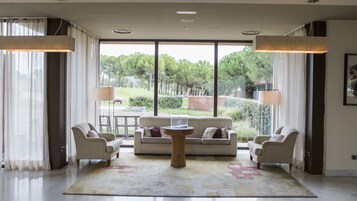 Una sala de estar amplia con un ventanal, dos sofás, una mesa de centro y dos lámparas de pie.