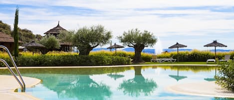 Una piscina al aire libre de temporada, sombrillas