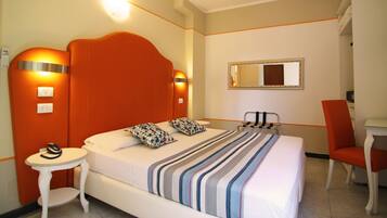 Una habitación de hotel con una cama grande, una mesita, una silla y un escritorio.