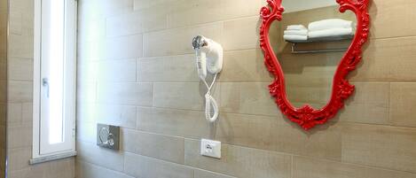 A modern bathroom with a bidet, a sink, and a mirror with a red frame.