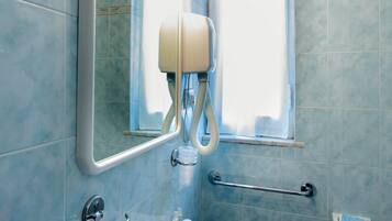 Ein Badezimmer mit Waschbecken, Spiegel und Haltegriffen.