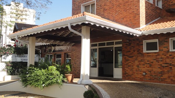 Traditional building with a covered entrance, flanked by columns and a scalloped awning.