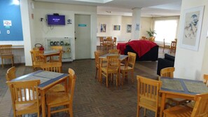 Enjoy meals in a spacious dining area with tables, chairs, and a mounted TV.
