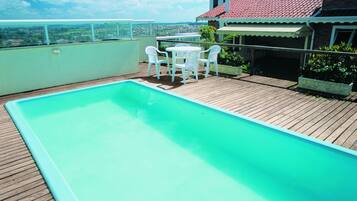 Una piscina al aire libre, sillones reclinables de piscina