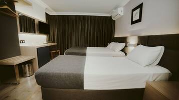 Habitación triple | Minibar, caja de seguridad en la habitación y escritorio