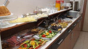 Un buffet proposant une variété d’aliments, notamment des fruits, des légumes et des viandes.