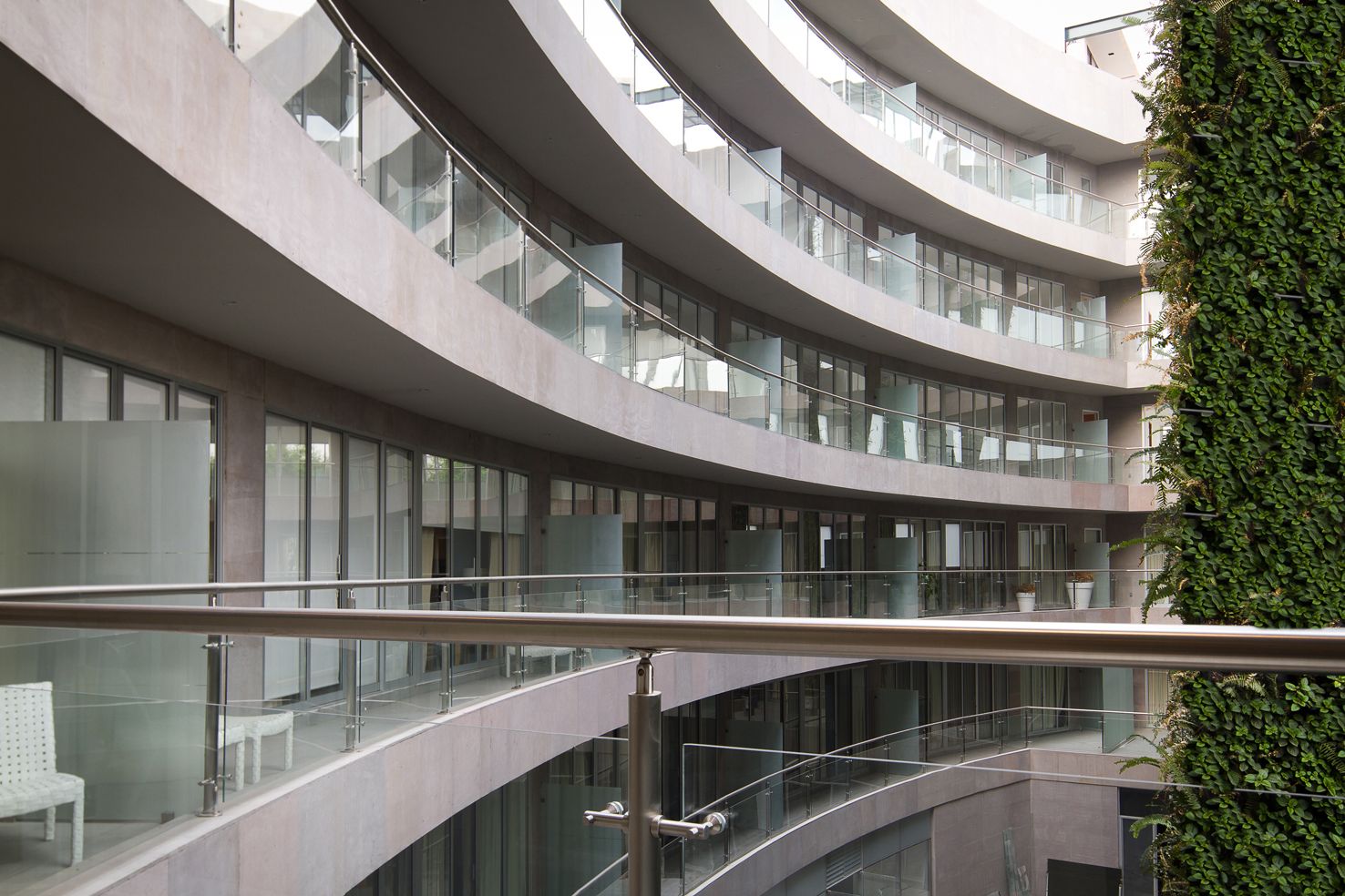 Un edificio moderno con balcones curvos y barandillas de vidrio.