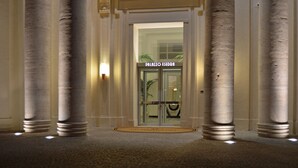 A grand entrance with tall columns and a glass door labeled "PALAZZO ESEDRA". - Hotel Palazzo Esedra (Naples)