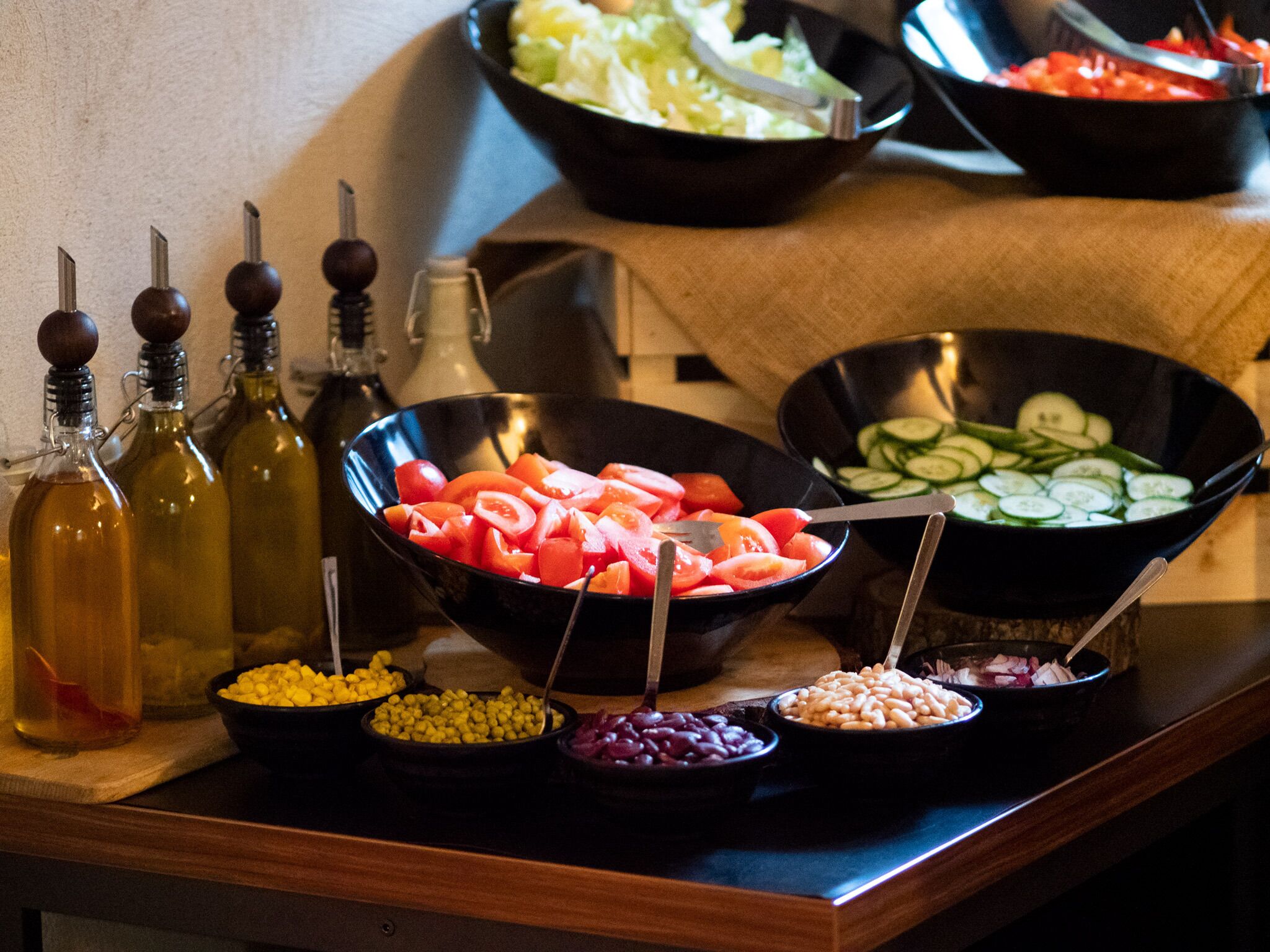 A buffet table with various food items and condiments.