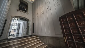A grand staircase leading to a door with a decorative panel. - Hotel Tobaco (Lodz)