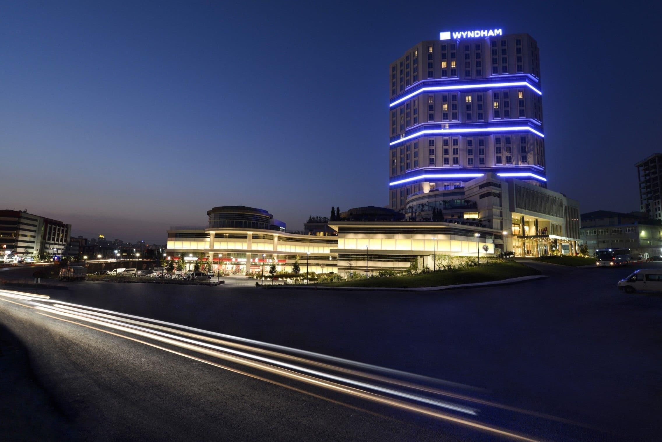 Een meerlaags hotel met een modern ontwerp, met opvallende bewegwijzering en verlichte lijnen op het gebouw.