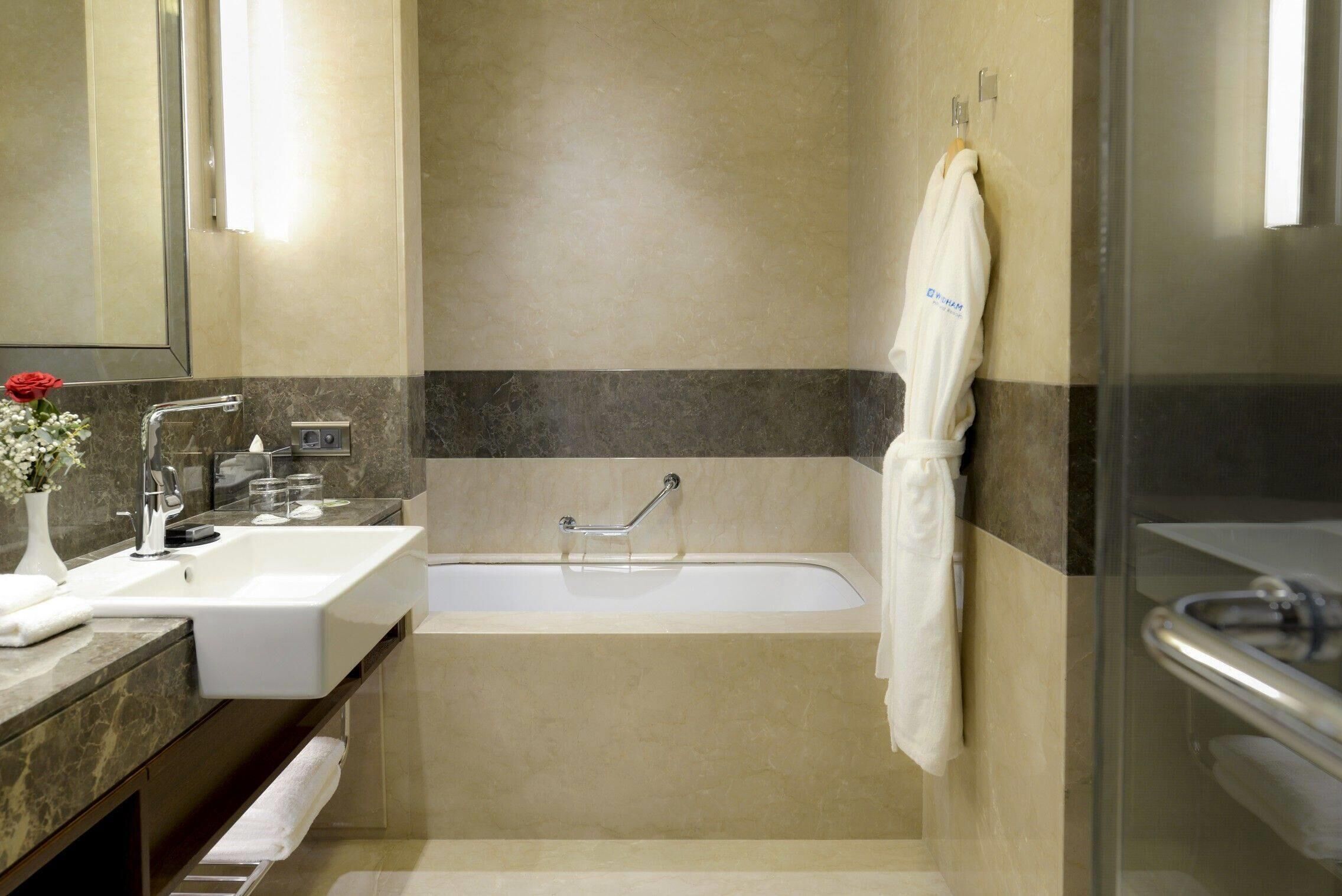 A modern bathroom with a sink, bathtub, and shower.
