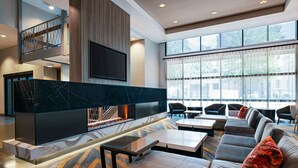 Eine moderne Lobby mit Kamin, Sitzgelegenheit und Treppe.