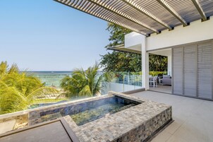 Una piscina al aire libre, sombrillas, sillones reclinables de piscina