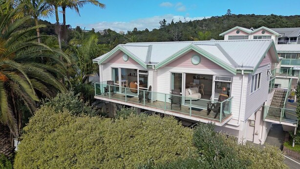 A two-story house with a balcony, surrounded by lush greenery and palm trees. - ASURE Admirals View Motel (Paihia)