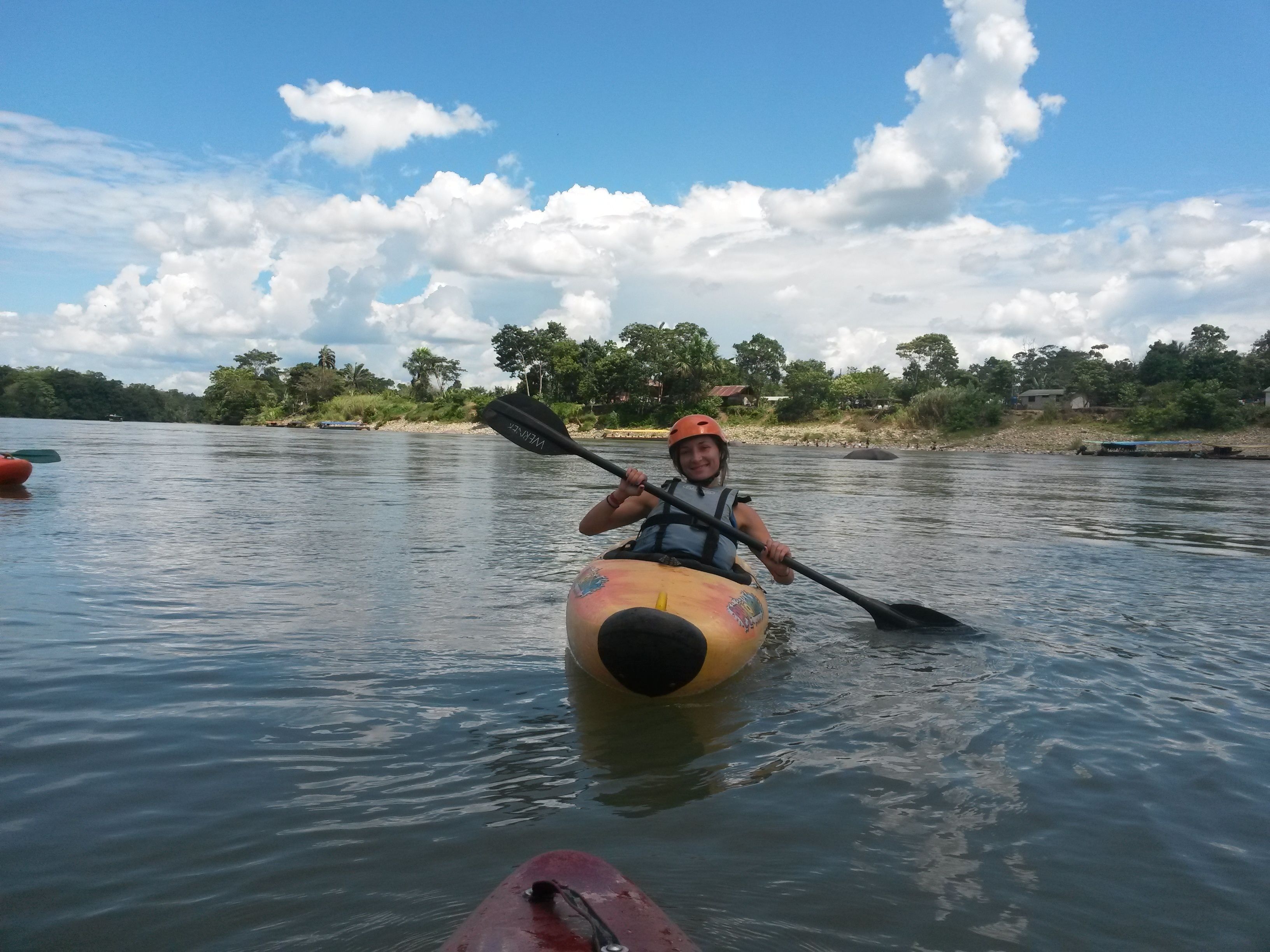 A person kayaking on a calm river.