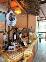 Una zona de bar con un mostrador de madera rústica, botellas de vino y un letrero colgante.