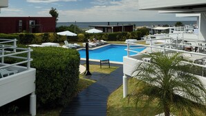 Un hôtel moderne doté d’une piscine, d’un espace extérieur aménagé et offrant une vue dégagée sur la mer.