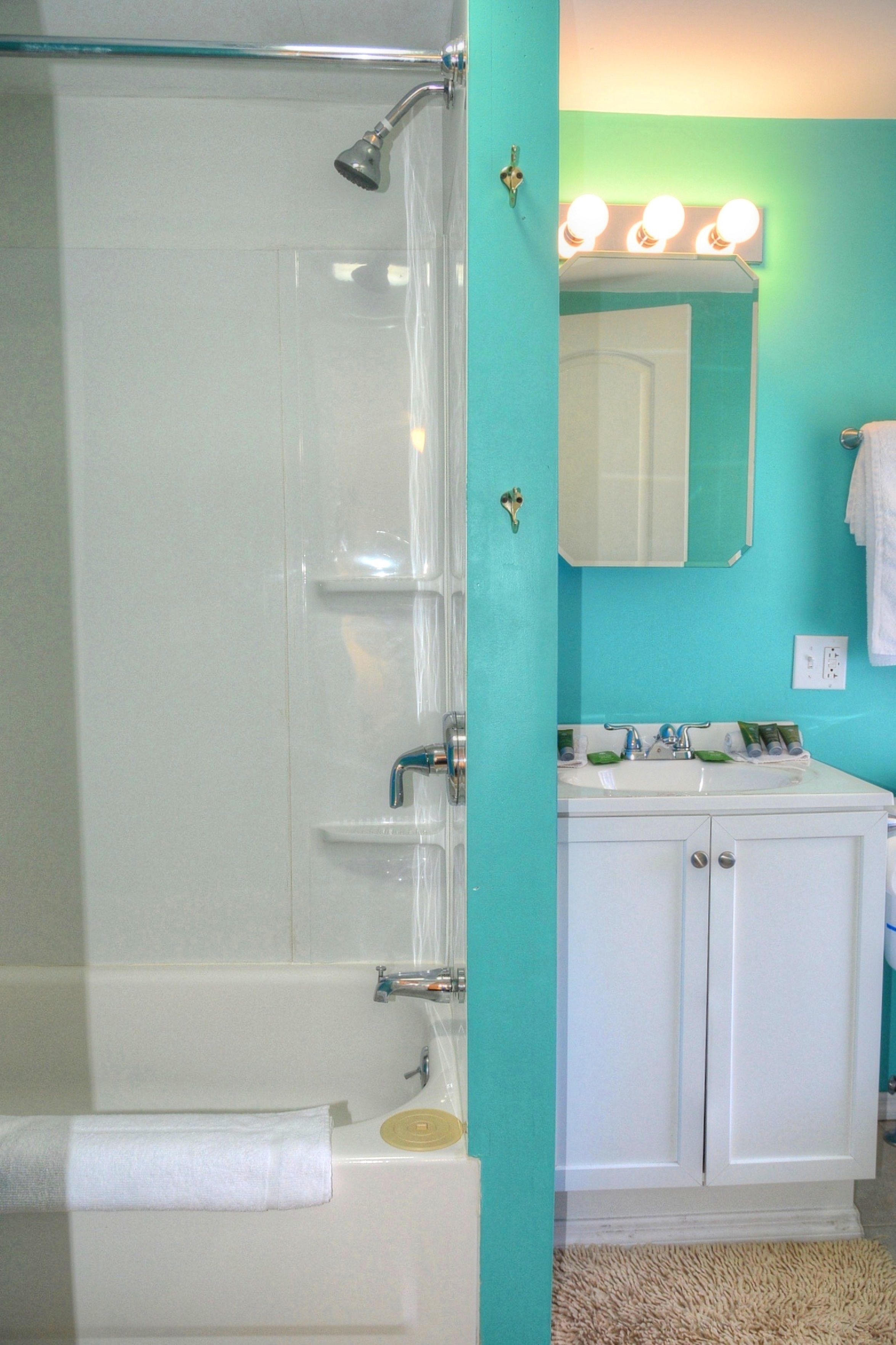 A bathroom with a bathtub, a sink, and a mirror.