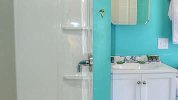 A bathroom with a bathtub, a sink, and a mirror.